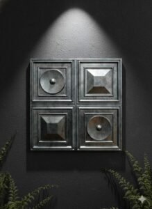 Modern metallic wall panel design featuring four decorative square panels with geometric and circular embossed details on a dark textured wall.