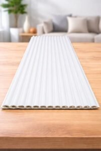 White fluted wall panel with vertical grooves displayed on a wooden table in a modern interior