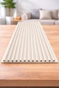 White fluted wall panel with vertical grooves displayed on a wooden table in a modern living room.