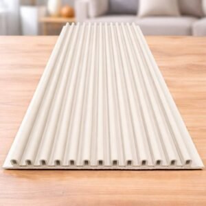 White fluted wall panel with vertical grooves displayed on a wooden table in a modern living room.