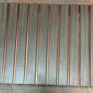 Grey wood-texture fluted wall panel with vertical grooves and copper metallic strips.