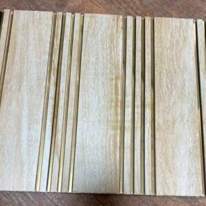 Light beige wood-textured fluted wall panel with vertical golden metallic strips for modern interior decoration.