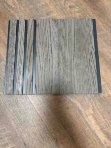 Grey wood-texture fluted wall panel with vertical grooves and dark recessed lines