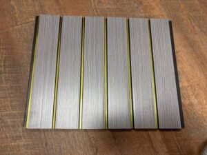 Grey wood-finish fluted panel with sleek golden vertical strips
