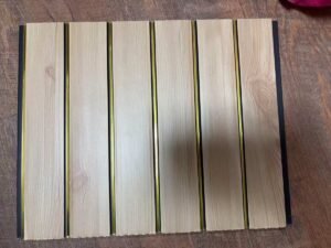 Light natural wood-finish fluted wall panel with vertical golden strips